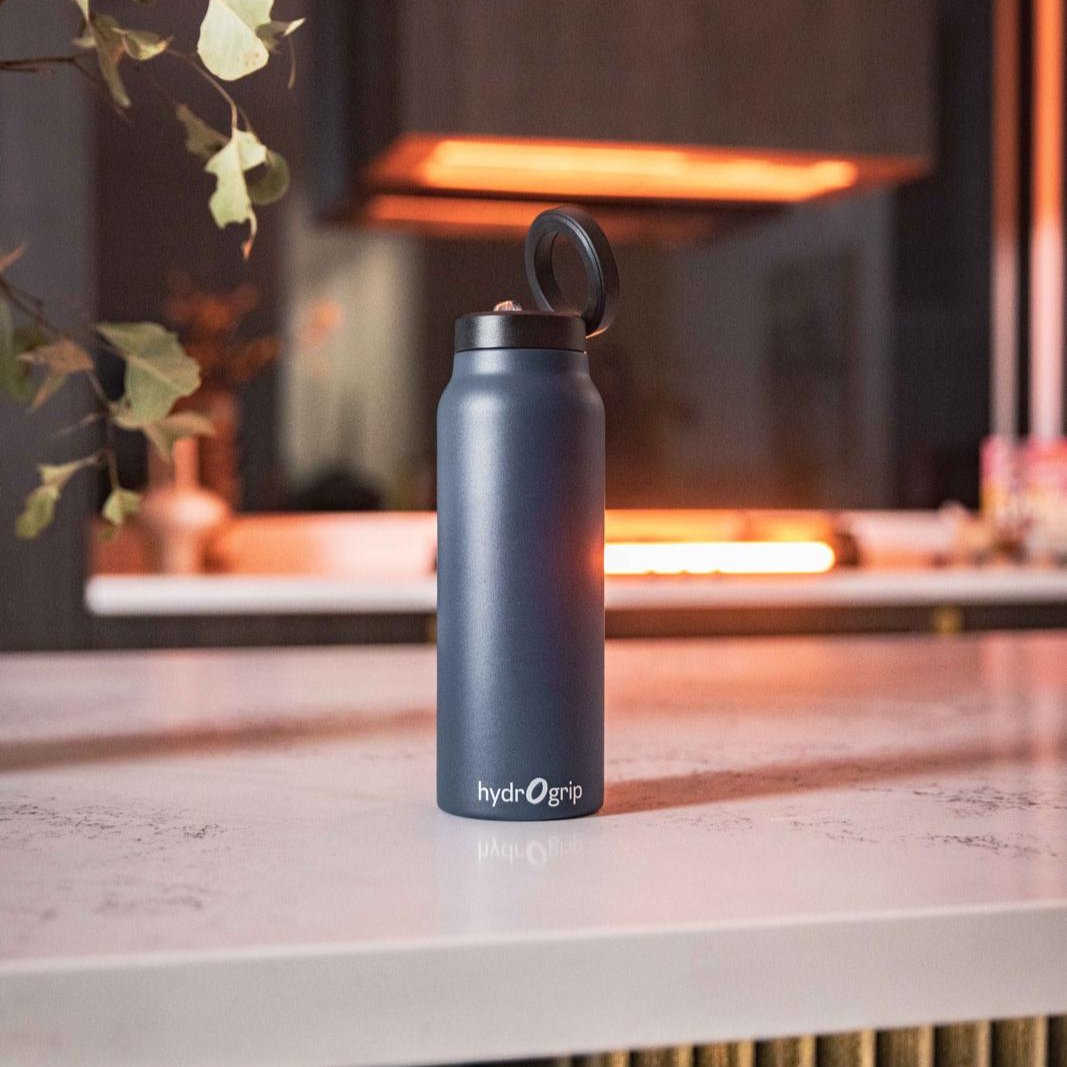 Hydrogrip insulated water bottle in Navy on a kitchen bench. Water Bottle that holds the phone.